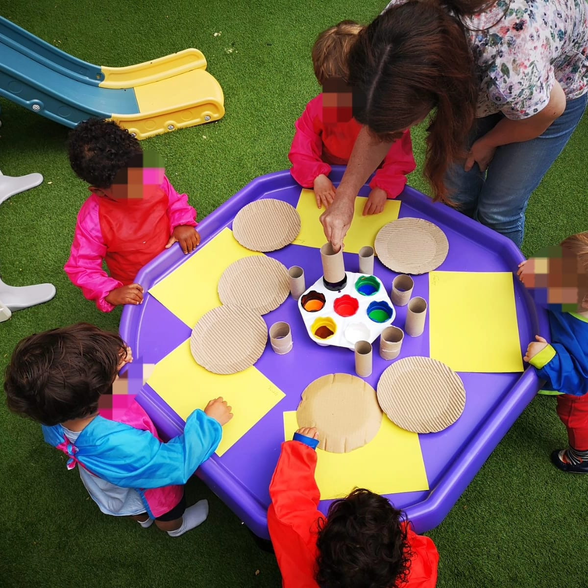 Children enjoying a colourful group painting activity at Talia's Teddies